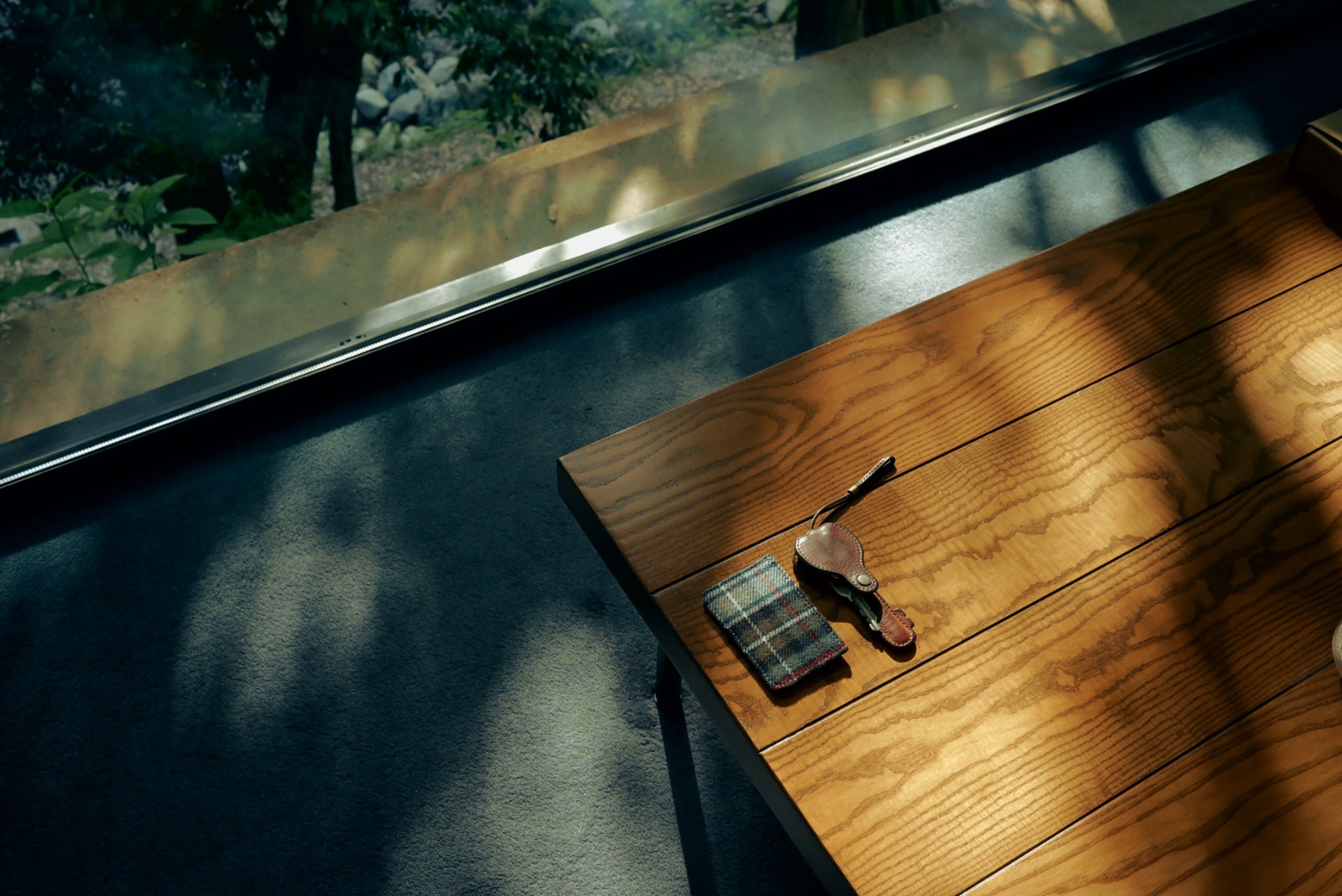 Spec D’ Art cardholder and key on a wooden table by a window